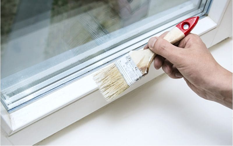 Image to symbolize when not to use eggshell paint showing a close-up of a window trim being painted