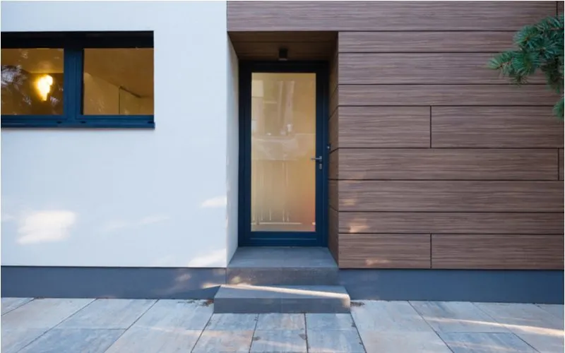 Idea for a house entrance with natural eco-friendly siding next to cement that frames the front glass door
