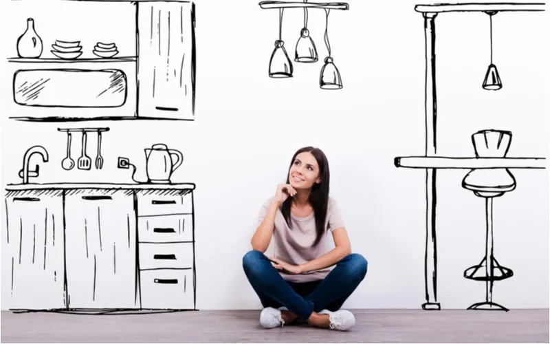 Woman dreaming about a new kitchen after using a kitchen design software to plan out her ideal layout