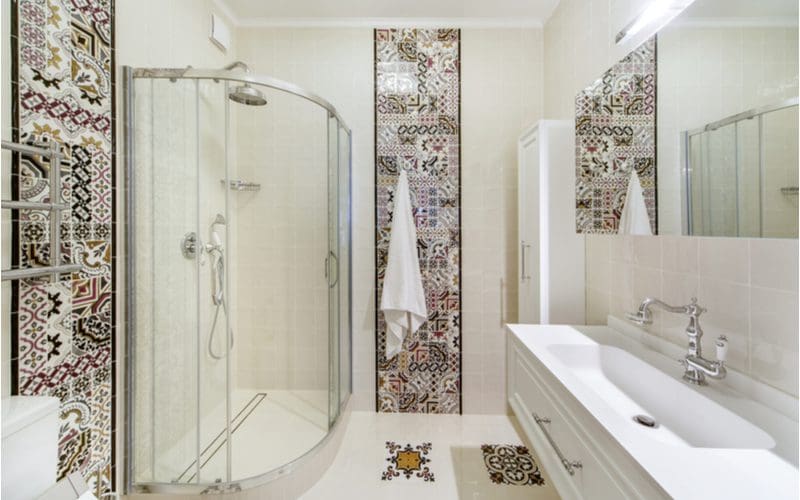Interior of a south-american style tile shower idea with mosaic tiles accenting all of the walls and some of the flooring