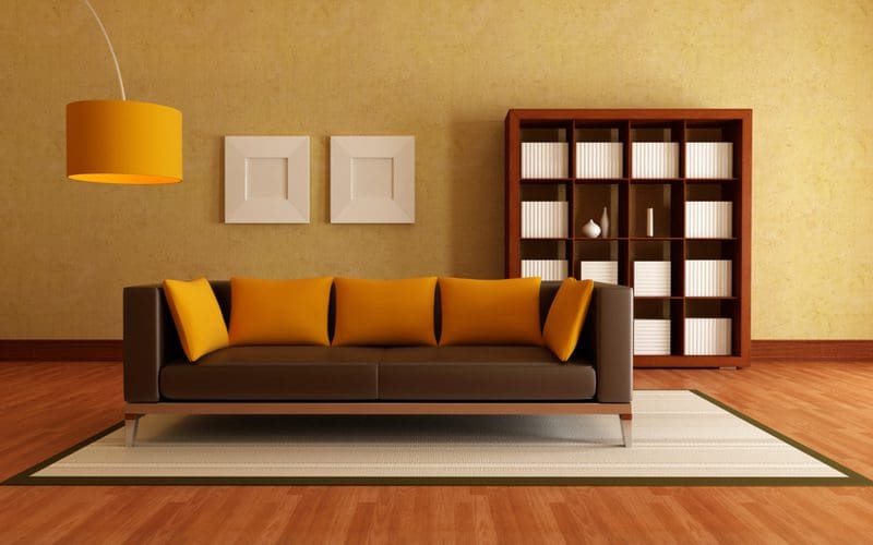 Dark brown couch living room idea with a dark brown couch and orange pillows