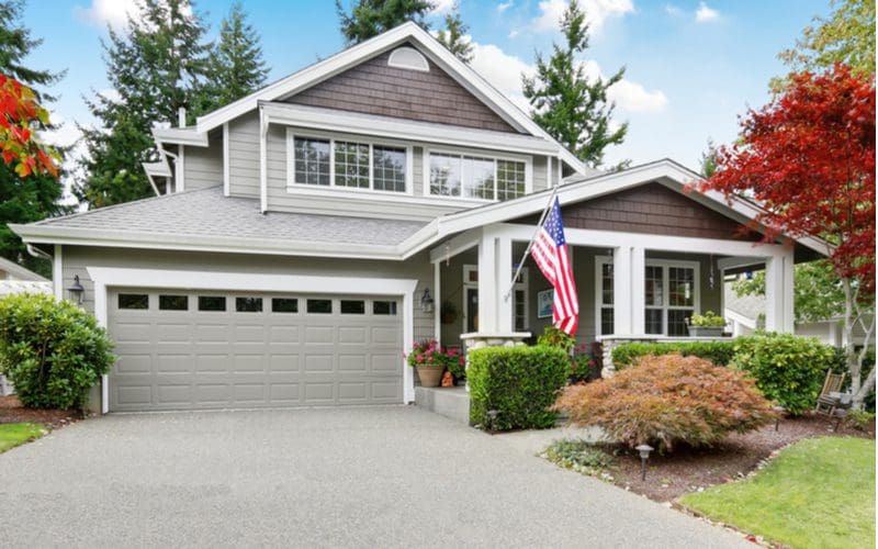 Grey house idea with a grey painted garage and nice mulch in front of an asphalt driveway