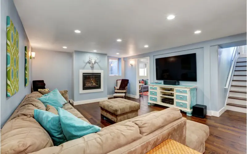 Natural light in a basement with dark wooden flooring and blue walls and white trim