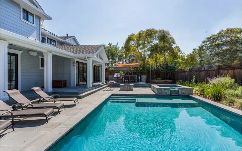 Big home in Menlo Park overlooking a costly inground swimming pool in a backyard