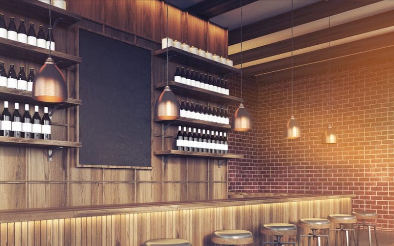 Image of a blackboard background basement bar idea with lots of wine bottles on the wall