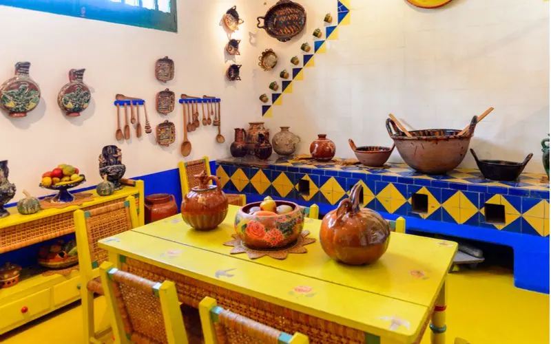Mexican-style kitchen in yellow and blue with bright painted furniture and decorated walls