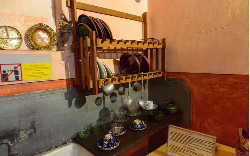 Mexican kitchen featuring a wooden hanging rack with lots of pots and pans hanging from it