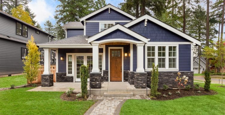 For a piece on front porch designs, a purple shake sided craftsman-style home sits with a beautiful paver path leading to the front door