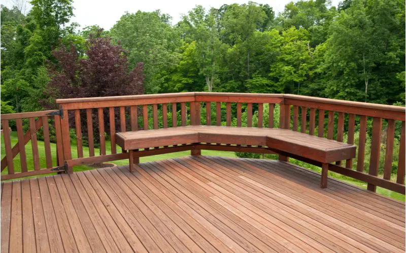 Image showing a standard height deck bench on a nice big wooden deck overlooking a wooded area