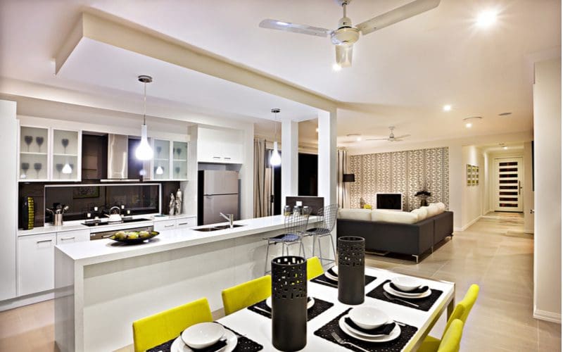 Photo of a kitchen ceiling fan above a modern black and white kitchen table with a nice open floorplan