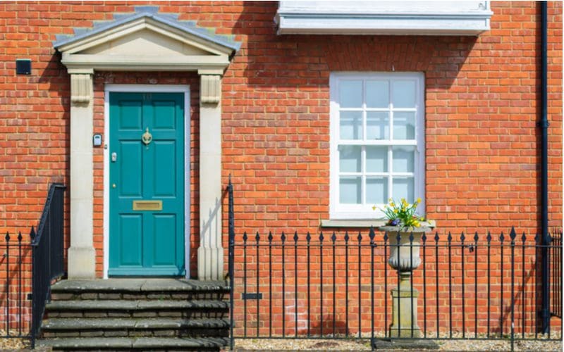 Teal, a unique front door color for a red brick house, on traditional brick home in England