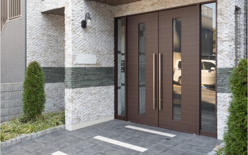 Slate colored tile leading up to a grand double-door entrance to a home