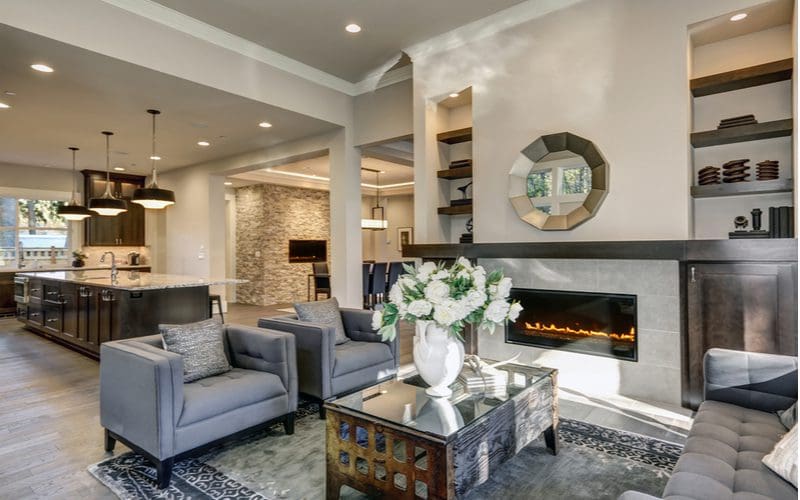 Chic-decorated living room with fireplace just off the kitchen in neutral earth tones