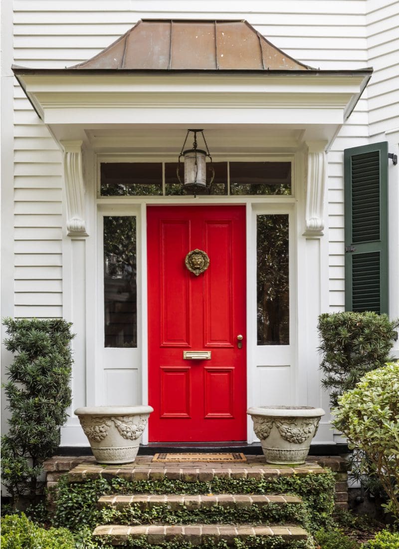 Bright red front door with a light fixture hanging above the porch overhang
