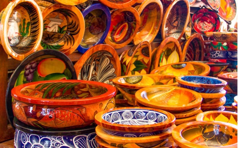 Mexican pottery on a table and mounted on a wall that is typically found in Mexican style kitchens
