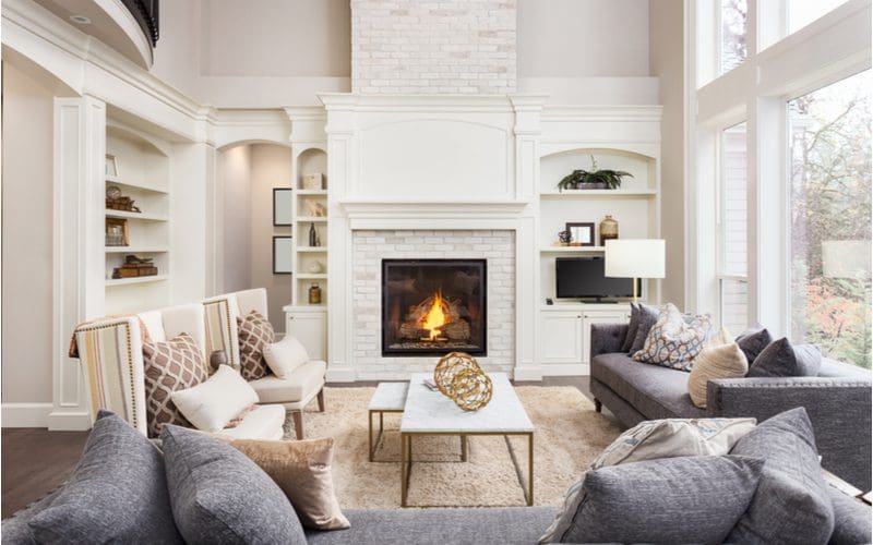 Image for a piece on living room with fireplace inspiration showing a gorgeous vaulted ceiling with a fireplace as the centerpiece