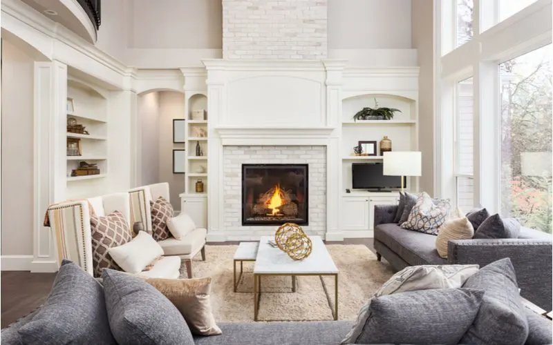 Image for a piece on living room with fireplace inspiration showing a gorgeous vaulted ceiling with a fireplace as the centerpiece