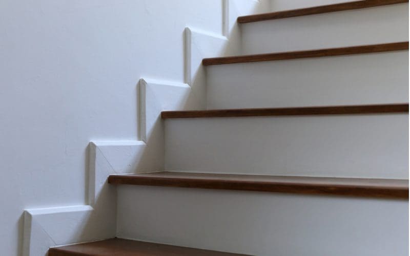Photo of a simple white waterfall baseboard stair trim idea