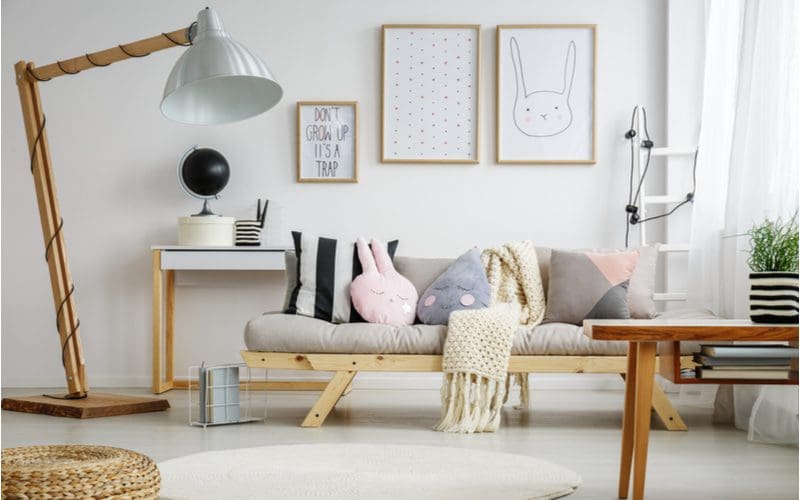 Creative living room with grey couch and funny animal print sketches on the walls