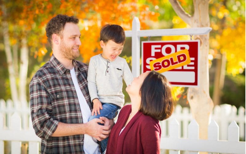 Illustration of the best time to sell a house with a couple standing in front of a sold sign in the Fall