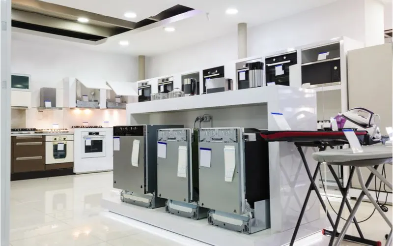 Dishwashers in standard sizes sit on a showroom floor in a modern white retailer's store