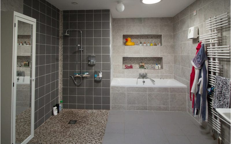 Walk in shower idea with shelves above a white porcelain drop-in tub