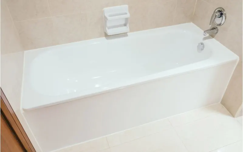 After bathtub refinishing, a white tub with grey tile surround looks great with chrome fixtures