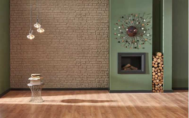Living room with fireplace below a strange planet-like decoration next to a brick wall