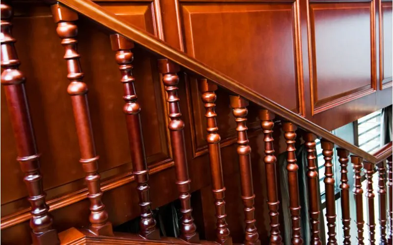 Stair trim idea featuring a dark staircase with dark wainscoting on on the wall