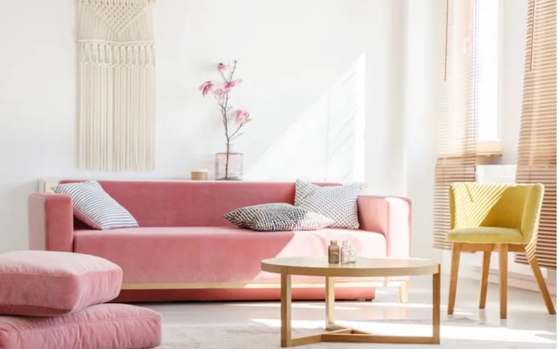 For a piece on what colors go with beige, a warm pink sofa with beige furniture and walls is pictured
