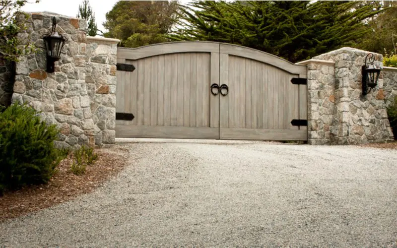 Double door wooden driveway gate idea with black farmhouse-style hardware