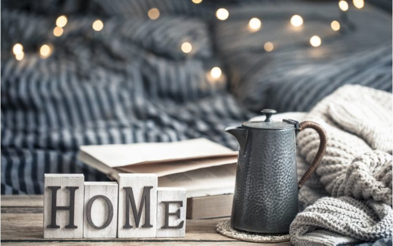Image of farmhouse decor ideas featuring a sign that says home and a metal tea kettle
