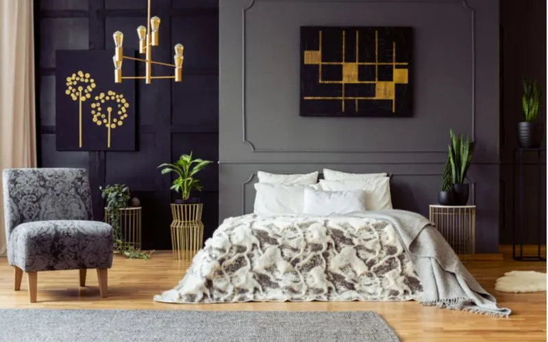 Hollywood Regency aesthetic bedroom idea with dark grey walls and gold accents with floral print chairs and natural wood framed end tables in the style of cages
