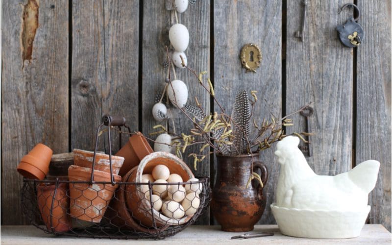 Image of a gathering of farmhouse décor including metal baskets, old keys and locks, and chicken statues