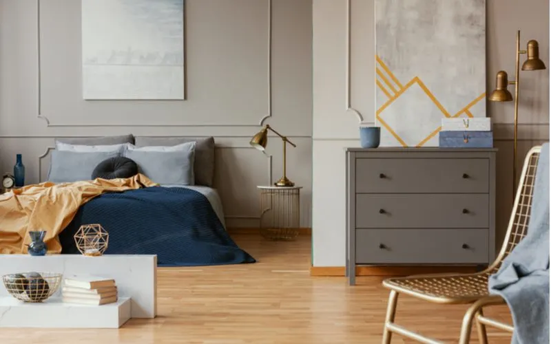 Fresh and Contemporary grey bedroom idea with a paneled or wainscoted wall painted grey with natural pine flooring