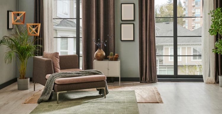 Featured image for a post titled Should Curtains Touch the Floor featuring a second-story living room with brown curtains and brown furniture with modern wood-look laminate flooring
