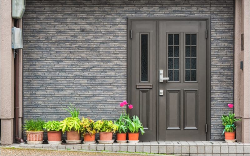 Gray brick home with a charcoal front door for a piece on front door colors for gray house ideas