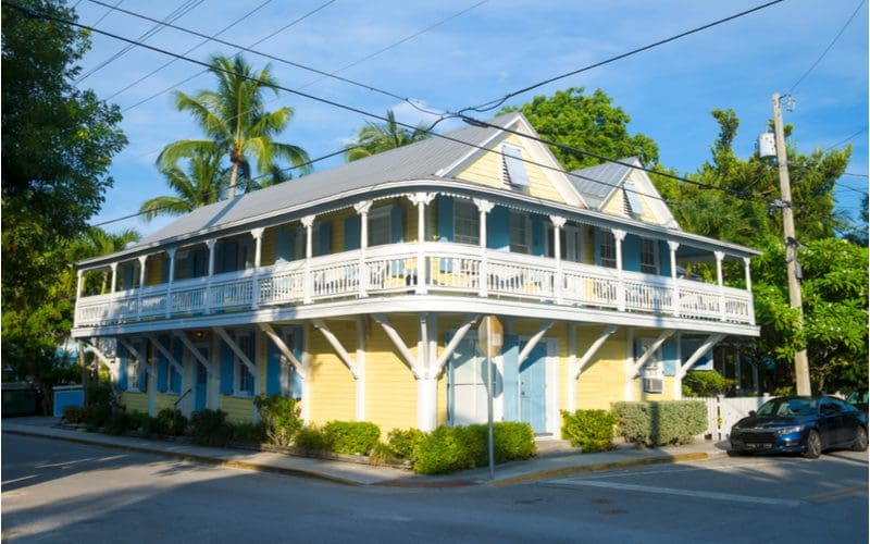 For a piece on porch overhang and roof ideas, an overhang below a wraparound porch on a yellow home in Key West