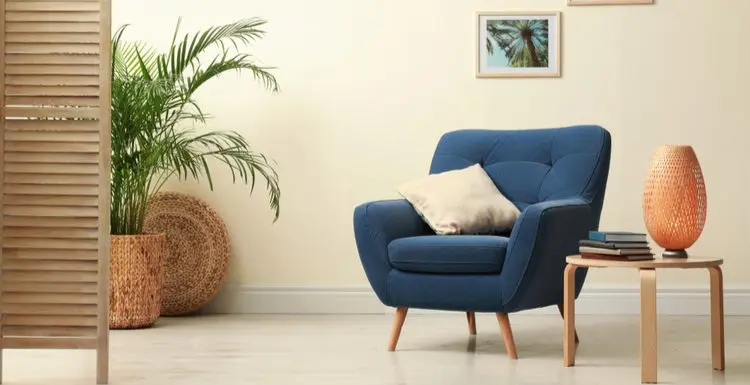 Featured image for a piece titled What Color Goes With Beige featuring a dark blue chair with a beige pillow and muted earth tone decorations