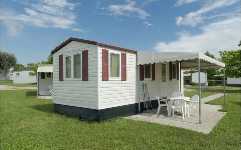 Image of vinyl and foam mobile home skirting below a small single-wide trailer home with a small awning