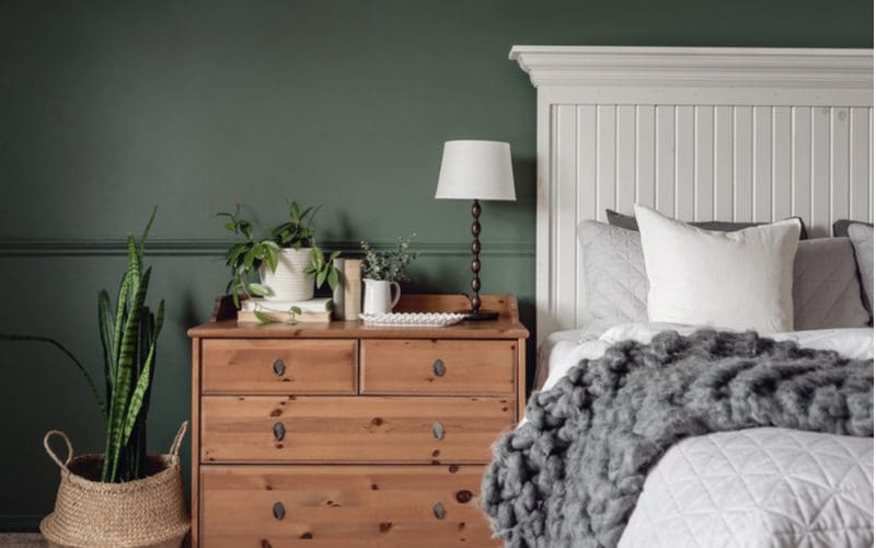 Grey bedroom idea with a white farmhouse-style bed and natural wood nightstand