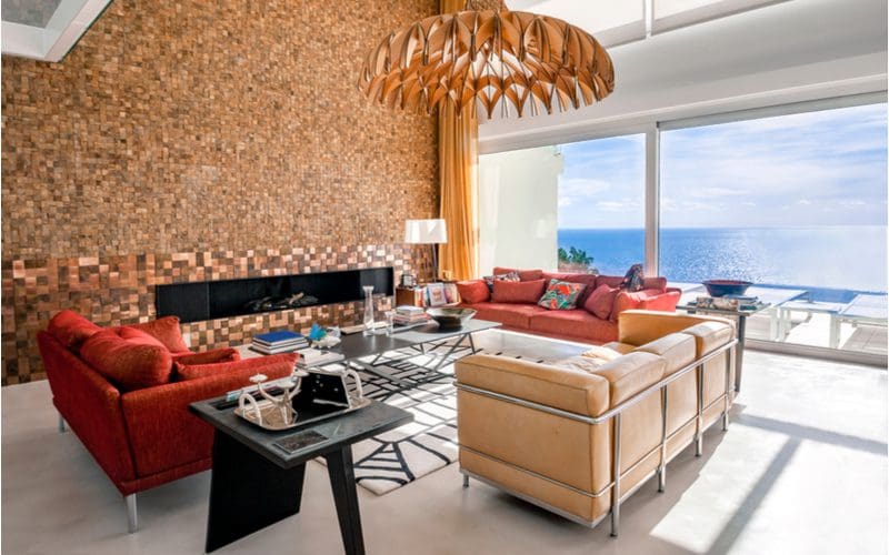 Long and skinny ventless fireplace framed by brown and tan fireplace tile in a living room that overlooks a deep blue ocean