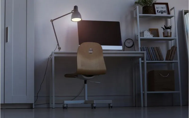Dorm room idea to invest in a good lamp showing a desk (sans student) utilized at night