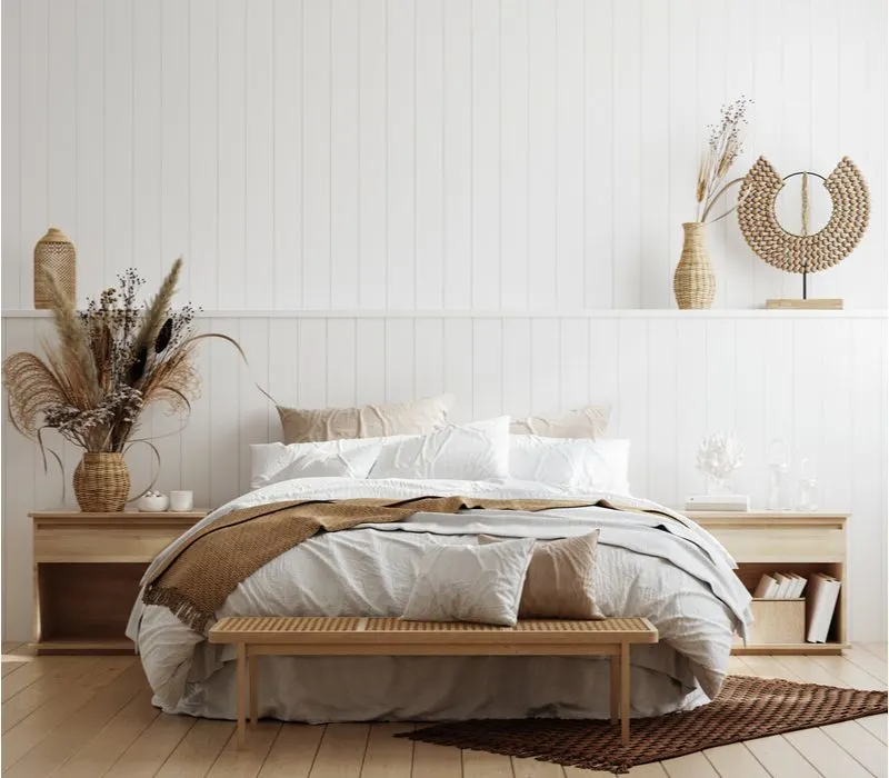 Coastal bedroom aesthetic idea with vertical white shiplap paneling, light wood floors, and natural wood accents