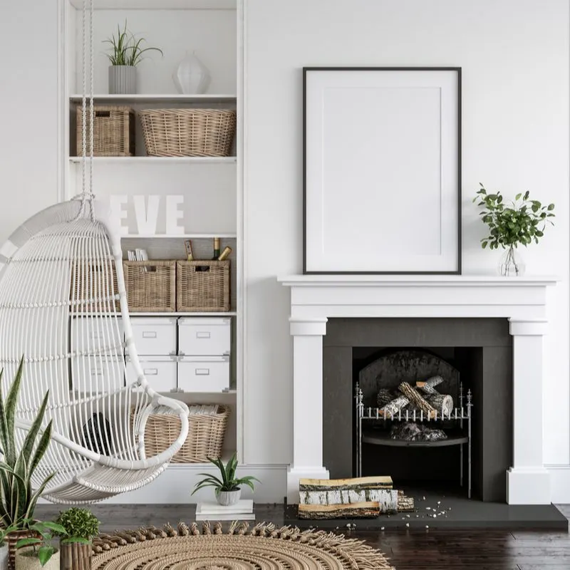 Image of a home decorated with farmhouse décor ideas with a hanging wicker chair, natural wood baskets, dark floors, and white walls