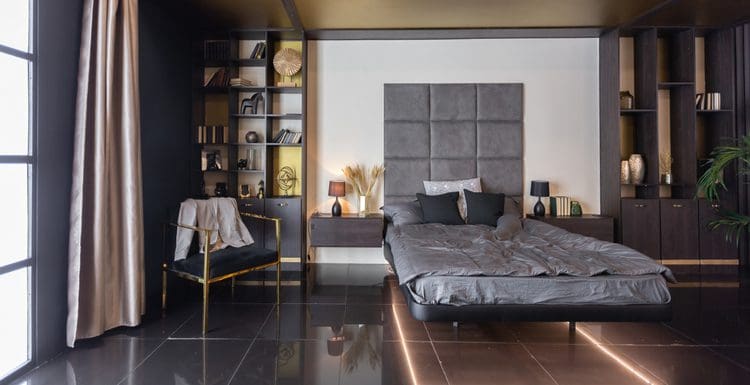 Masculine bedroom idea with a dark aesthetic with a white accent wall and dark grey bedding with an underlit bed