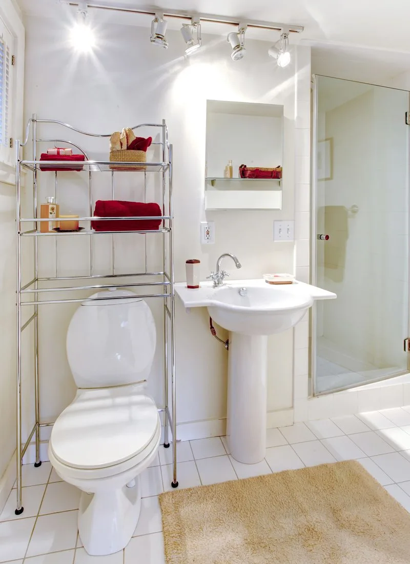 Small bathroom storage idea featuring an over-the-toilet metal shelving system