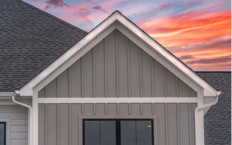 Board and batten siding that comes in vinyl displayed on a house that sits against a beautiful dusk sunset