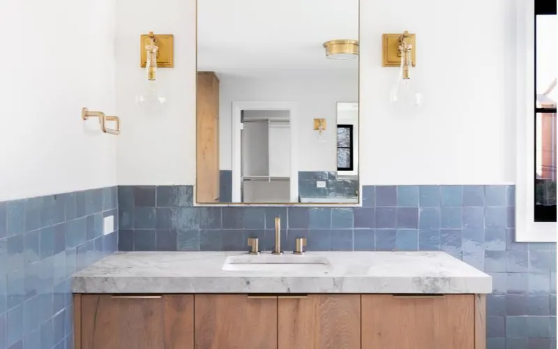 Blue white and gold bathroom idea with blue tile and gold fixtures