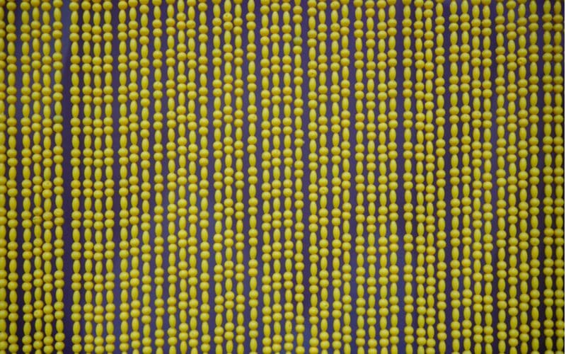 For a piece on door curtain bead ideas, yellow and blue beads hang from an unpictured doorway